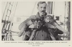 Captain Harwood Steele on board the 'Arctic,' with two husky pups he brought Captain Harwood Steele on board the 'Arctic,' with two husky pups he brought