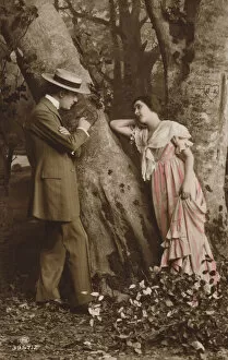 Couple scratching their initials into a tree (photo)