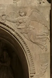 Genius holding a bowl of fruit, symbolising plenty, from a spandrel of an aivans Genius holding a bowl of fruit, symbolising plenty, from a spandrel of an aivans