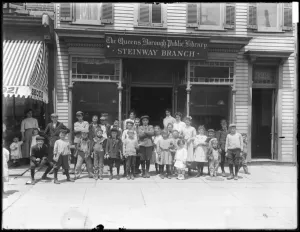 Group portrait of children in front of the Steinway branch of the Queens Borough Public Group portrait of children in front of the Steinway branch of the Queens Borough Public
