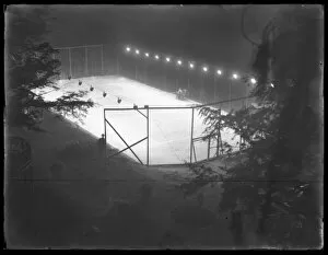 High angle view of an unidentified clay tennis court at night, undated