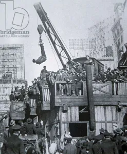 Houdini escaping from a strait-jacket while suspended from a crane in New York City Houdini escaping from a strait-jacket while suspended from a crane in New York City
