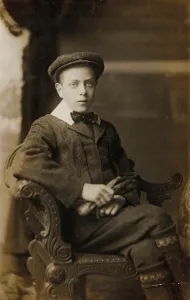 Serious looking boy in cap, suit, Eton collar, holding gloves (b/w photo) Serious looking boy in cap, suit, Eton collar, holding gloves (b/w photo)