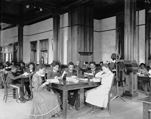 Male and Female Students Reading at Tables in Library, Tuskegee Institute, Alabama, 1902 (b/w photo)