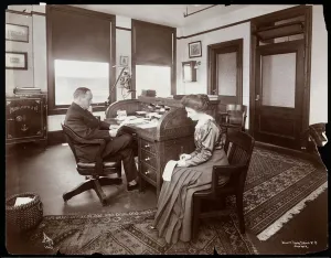 Man with his secretary taking dictation in a private office at Parke, Davis & Co Man with his secretary taking dictation in a private office at Parke, Davis & Co