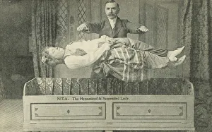 Nita, the hypnotized and suspended lady, magician performing a levitation trick (b/w photo) Nita, the hypnotized and suspended lady, magician performing a levitation trick (b/w photo)