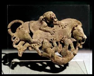 Ornamental plaque depicting a wild boar struggling with two tigers, from Tomb 3 at Shih-chai-shan Ornamental plaque depicting a wild boar struggling with two tigers, from Tomb 3 at Shih-chai-shan