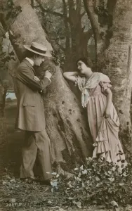 Postcard of lovers carving a heart on a tree, sent in 1913 (hand-coloured photo) Postcard of lovers carving a heart on a tree, sent in 1913 (hand-coloured photo)