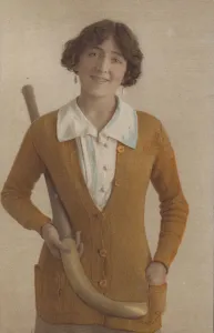 English Rose Gallery: Pretty girl, in knitted jumper, with pearl earrings, holding hockey stick (photo)