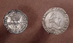 Two silver coins: the one on the left: the reverse of a quarter of ecus coin Two silver coins: the one on the left: the reverse of a quarter of ecus coin