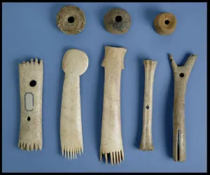 Spindle whorls, antler weaving combs and a bone shuttle and loom fitting, Iron Age (bone) Spindle whorls, antler weaving combs and a bone shuttle and loom fitting, Iron Age (bone)