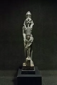 Ancient Egyptian Gallery: Standing statue of Ramesses VI presenting a votive statuette of Amun usurped from Ramesses IV or V