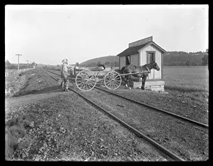 Unidentified man loading milk on to horse-drawn cart parked over railroad tracks outside Unidentified man loading milk on to horse-drawn cart parked over railroad tracks outside