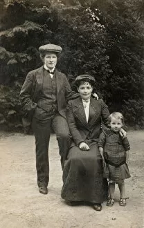 Two women, one dressed as man, with female child (b / w photo)