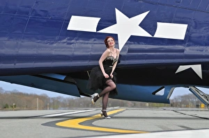 1940s style pin-up girl in cocktail dress posing in front of a TBM Avenger 1940s style pin-up girl in cocktail dress posing in front of a TBM Avenger