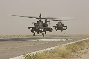 Two AH-64 Apache helicopters prepare to land on on the runway Two AH-64 Apache helicopters prepare to land on on the runway