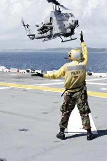 Airman directs an AH-1W Super Cobra onto the flight deck of USS Essex Airman directs an AH-1W Super Cobra onto the flight deck of USS Essex
