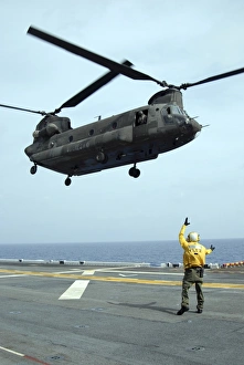 Airman directs an Army CH-47 Chinook helicopter on the flight deck Airman directs an Army CH-47 Chinook helicopter on the flight deck