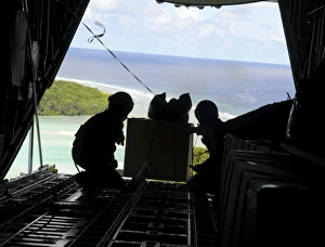 Airmen push out a pallet of donated goods from a C-130 Hercules Airmen push out a pallet of donated goods from a C-130 Hercules