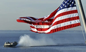 American flag blowing in the wind with a hovercraft in the background American flag blowing in the wind with a hovercraft in the background