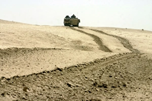 An amphibious assault vehicle rolls through a desert field An amphibious assault vehicle rolls through a desert field