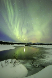 Aurora borealis over a creek by Fish Lake, Yukon, Canada Aurora borealis over a creek by Fish Lake, Yukon, Canada