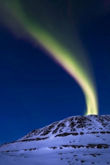 An aurora borealis shooting up from Toviktinden Mountain, Norway An aurora borealis shooting up from Toviktinden Mountain, Norway