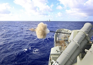 The Australian navy frigate HMAS Warramunga fires its 5-inch gun during a surface The Australian navy frigate HMAS Warramunga fires its 5-inch gun during a surface