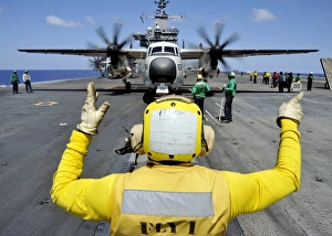 Aviation Boatswains Mate directs a C-2A Greyhound onto a catapult Aviation Boatswains Mate directs a C-2A Greyhound onto a catapult
