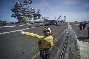Aviation Boatswains Mate directs an F/A-18E Super Hornet Aviation Boatswains Mate directs an F/A-18E Super Hornet
