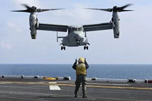 Images Dated 16th February 2013: An aviation boatswains mate directs the landing of an MV-22 Osprey