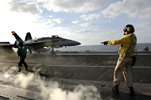 Aviation Boatswains Mate ensures an F/A-18C Hornet is cleared for launch Aviation Boatswains Mate ensures an F/A-18C Hornet is cleared for launch