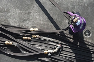 Aviation Boatswains Mate gathers a fuel hose on the flight deck Aviation Boatswains Mate gathers a fuel hose on the flight deck
