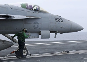 An aviation boatswains mate prepares an F/A-18E Super Hornet to launch An aviation boatswains mate prepares an F/A-18E Super Hornet to launch