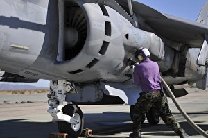 Aviation fuel technician attaches a fuel line to an AV-8B Harrier Aviation fuel technician attaches a fuel line to an AV-8B Harrier