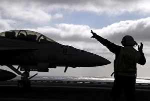Aviations Boatswains Mate directs an F/A-18E Super Hornet Aviations Boatswains Mate directs an F/A-18E Super Hornet