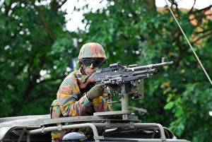 A Belgian Army soldier handling a machine gun atop a Unimog vehicle A Belgian Army soldier handling a machine gun atop a Unimog vehicle