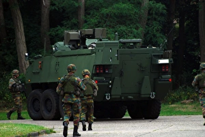 Belgian Infantry soldiers walk alongside the Piranha IIC armoured infantry vehicle Belgian Infantry soldiers walk alongside the Piranha IIC armoured infantry vehicle