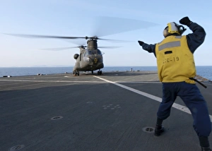 Boatswains Mate signals to an Army CH-47 Chinook helicopter Boatswains Mate signals to an Army CH-47 Chinook helicopter