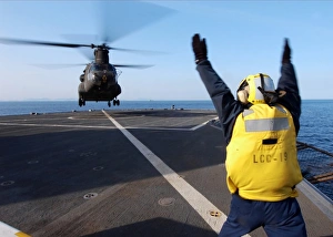 Boatswains Mate signals to a CH-47 Chinook helicopter Boatswains Mate signals to a CH-47 Chinook helicopter