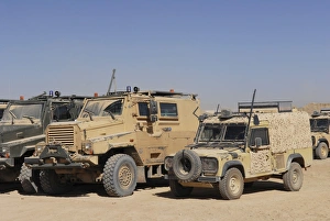 A British Armed Forces Snatch Land Rover parked next to other military vehicles A British Armed Forces Snatch Land Rover parked next to other military vehicles