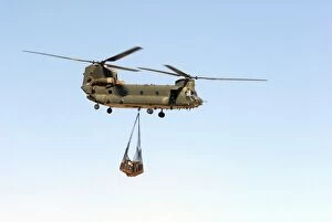 A CH-47 Chinook of the Royal Air Force transports a sling load of pallets