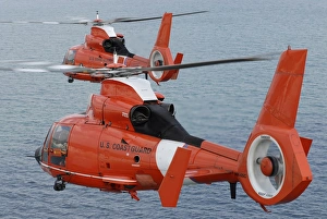Two Coast Guard HH-65C Dolphin helicopters fly in formation over the Atlantic Ocean Two Coast Guard HH-65C Dolphin helicopters fly in formation over the Atlantic Ocean