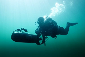 Combat diver navigates the waters using a diver propulsion vehicle Combat diver navigates the waters using a diver propulsion vehicle