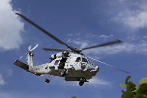 A Crew Chief looks out the side door of a helicopter in flight A Crew Chief looks out the side door of a helicopter in flight
