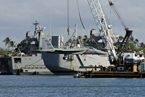An F-15 Eagle gets a lift from a barge crane An F-15 Eagle gets a lift from a barge crane