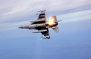 An F-16 Fighting Falcon drops flares while performing manuevers An F-16 Fighting Falcon drops flares while performing manuevers