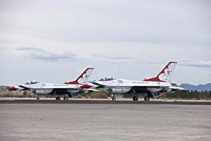 Two F-16C Thunderbirds sit on the runway at Nellis Air Force Base, Nevada Two F-16C Thunderbirds sit on the runway at Nellis Air Force Base, Nevada