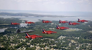 A F-22 Raptor flies in formation with the Royal Air Force Aerobatic Team, The Red Arrows A F-22 Raptor flies in formation with the Royal Air Force Aerobatic Team, The Red Arrows