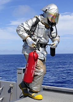 Firefighter carries a CO2 fire extinguisher onto the flight deck of USS Denver Firefighter carries a CO2 fire extinguisher onto the flight deck of USS Denver